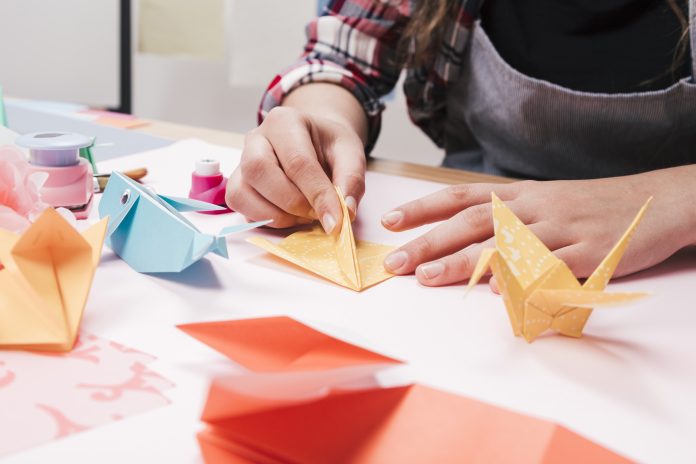 close-up-z-kobiecej-reki-co-kreatywne-rzemioslo-sztuki-za-pomoca-papieru-origami origami