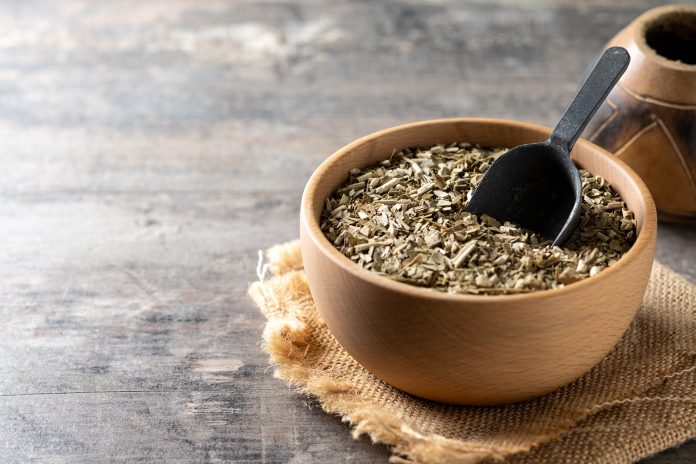 Traditional yerba mate in wooden bowl on wooden table yerba mate