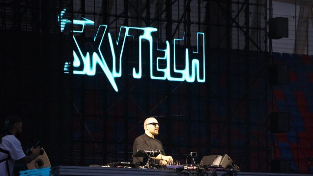 DJ Skytech za konsoletą w otoczeniu efektów świetlnych i laserów na koncercie W górę serca w Opolu